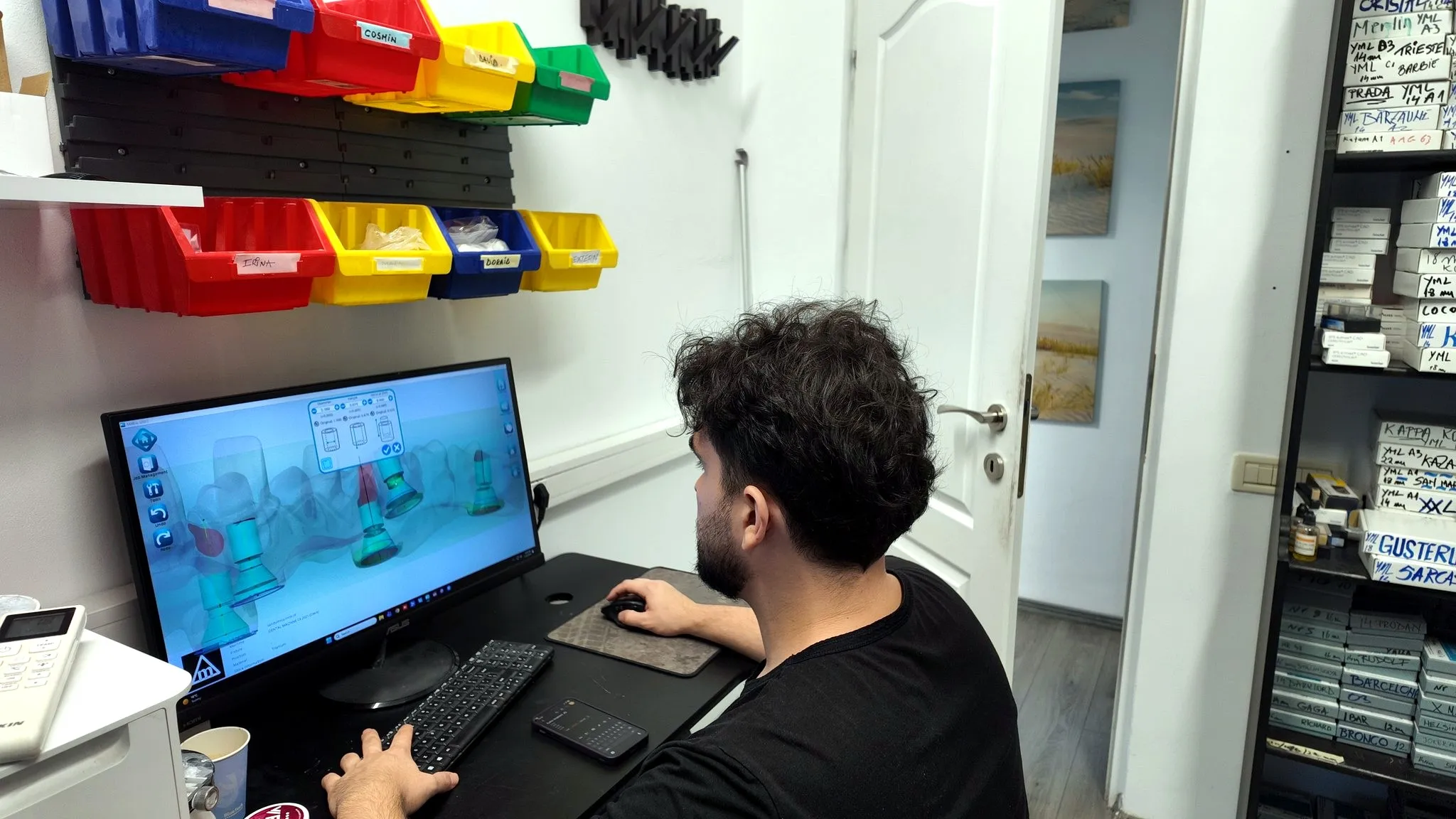 A technician designing a crown at the CAD/CAM station in the partner clinic’s in-house dental laboratory